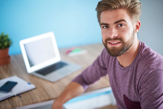 Portret van een man in zijn kantoor aan huis