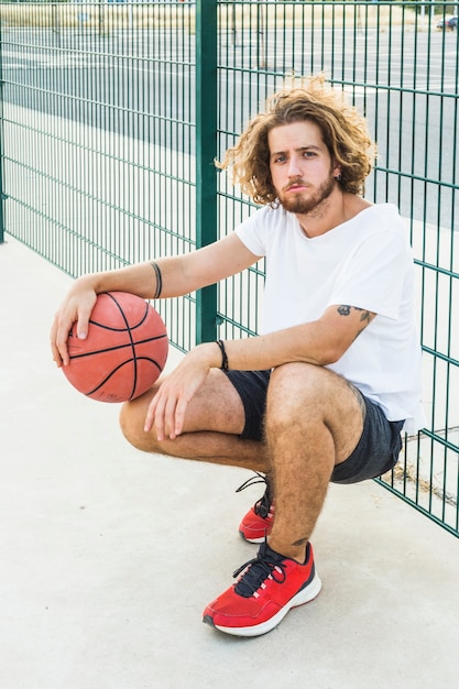 Gratis foto portret van een man met basketbal voor het gerecht