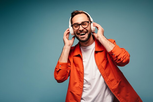 Portret van een man met een bril die favoriete liedjes in een koptelefoon luistert