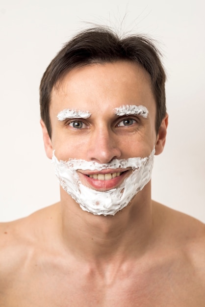 Gratis foto portret van een man met scheerschuim op gezicht