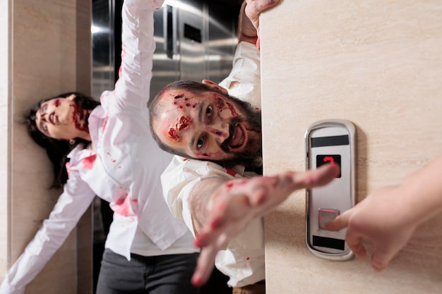Portret van een man zombie die kantoor aanvalt, ontsnapt uit de lift en er gevaarlijk uitziet met bloedige littekens. Angstaanjagende agressieve monsters die angstaanjagend zijn en mensen achtervolgen, hersenetende wandelaars.