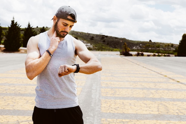 Gratis foto portret van een mannelijke atleet met behulp van slimme horloge