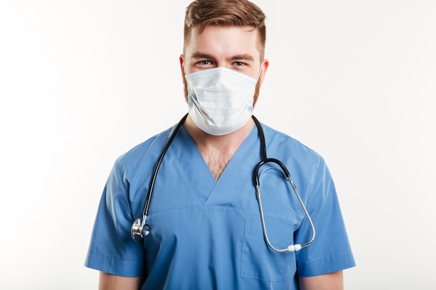 Portret van een mannelijke chirurg die stethoscoop en masker draagt