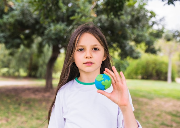Portret van een meisje met klei wereld bol in de hand