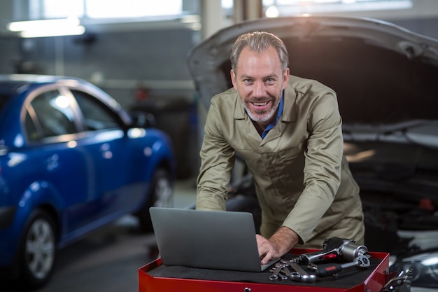 Portret van een monteur met behulp van laptop