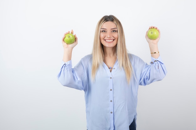 portret van een mooi meisjesmodel dat staat en verse appels vasthoudt.