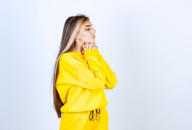 Portret van een mooi vrouwenmodel dat staat en poseert in een geel t-shirt