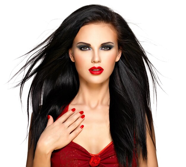 Portret van een mooie brunette vrouw met rode nagels en lippen