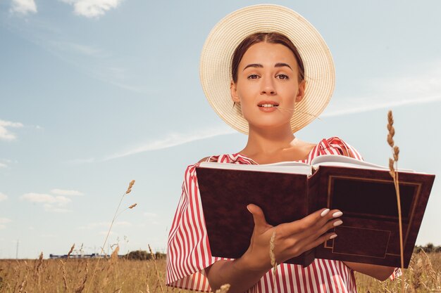 Portret van een mooie dame. leest een boek in het veld. bereid je voor op toelating tot de universiteit.