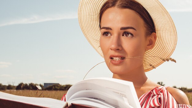 Portret van een mooie dame. leest een boek in het veld. bereid je voor op toelating tot de universiteit.