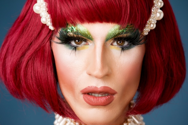 Portret van een mooie drag-persoon die make-up en pruik draagt