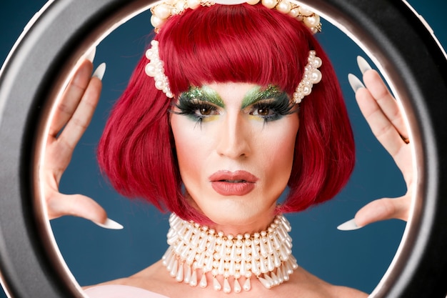 Portret van een mooie drag-persoon die make-up en pruik draagt