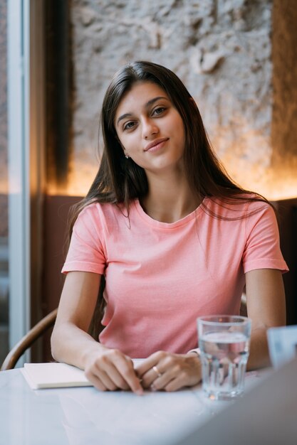 Portret van een mooie jonge brunette in café