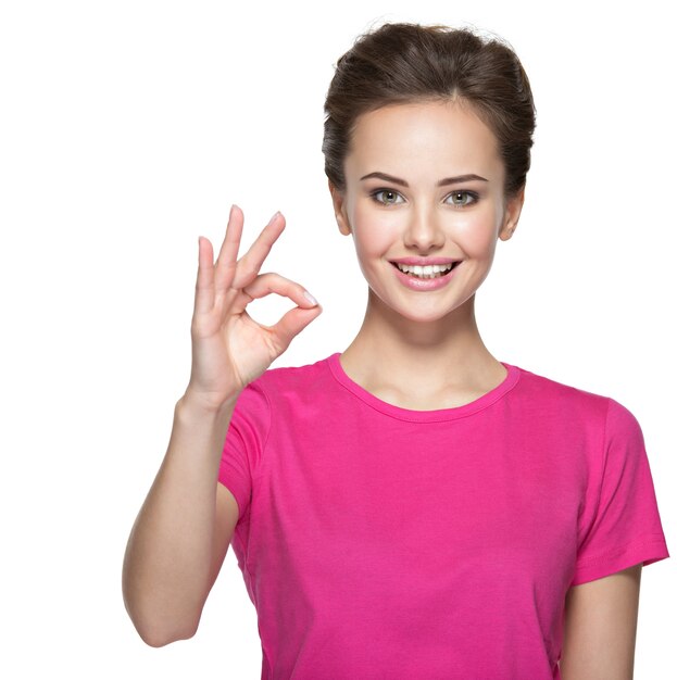 Gratis foto portret van een mooie jonge gelukkige vrouw met ok gebaar