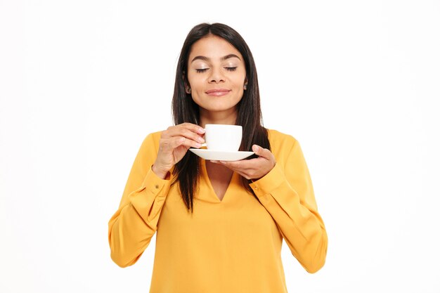 Portret van een mooie jonge kop van de vrouwen ruikende thee