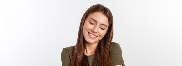 Portret van een mooie jonge vrouw die naar de camera kijkt en glimlacht geïsoleerd op een witte achtergrond