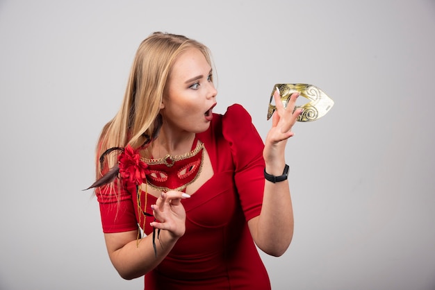 Portret van een mooie jonge vrouw in een carnavalsmasker.