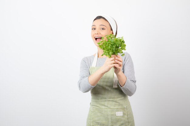 Portret van een mooie schattige vrouw met een straal verse peterselie