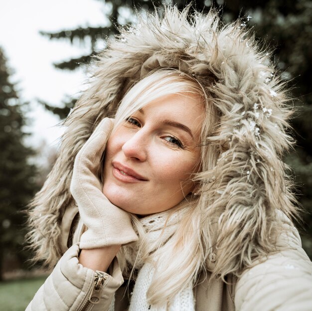 Portret van een mooie vrouw die de winterjas met capuchon draagt
