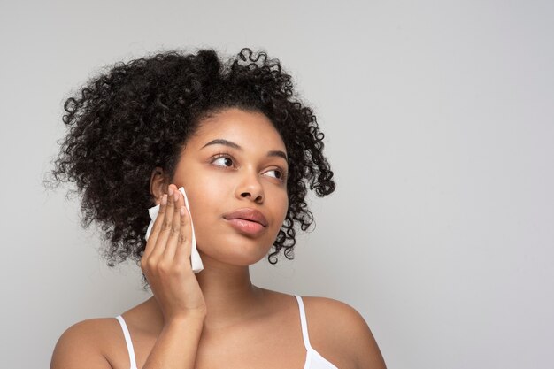 Portret van een mooie vrouw die haar make-up verwijdert met een tissue