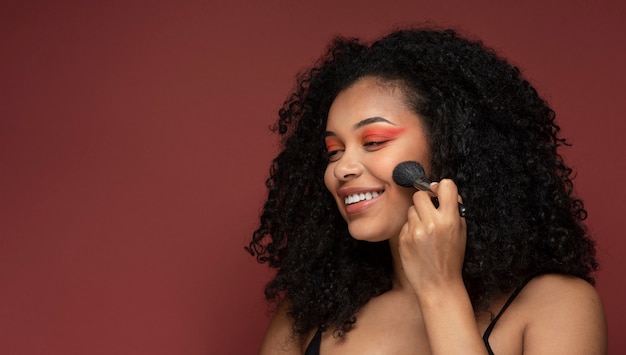 Portret van een mooie vrouw die make-up op haar gezicht aanbrengt