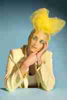 Gratis foto portret van een mooie vrouw die poseert met een avantgarde hoofddeksel