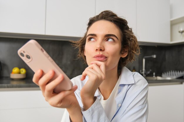 Portret van een mooie vrouw thuis met een smartphone die online winkelt via een mobiele telefoonapp