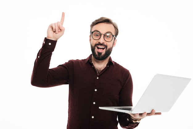 Portret van een opgewonden bebaarde man met laptopcomputer