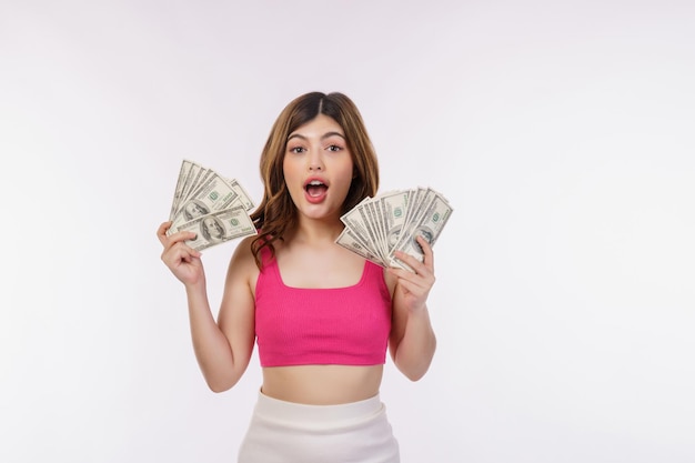 Gratis foto portret van een opgewonden jonge vrouw met een stel dollars bankbiljetten geïsoleerd op een witte achtergrond