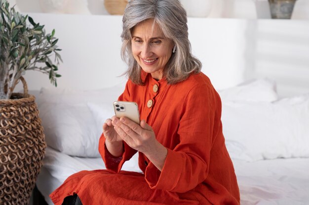 Portret van een oudere vrouw die een smartphone gebruikt
