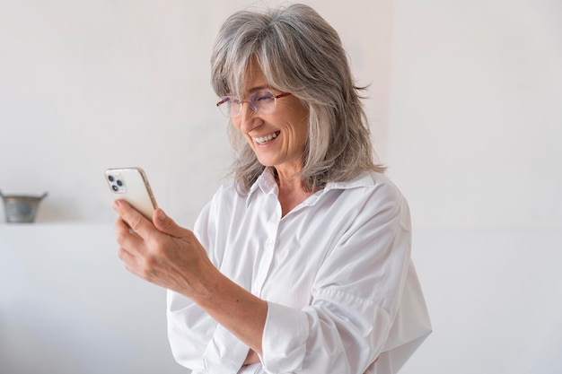 Portret van een oudere vrouw die een smartphone gebruikt