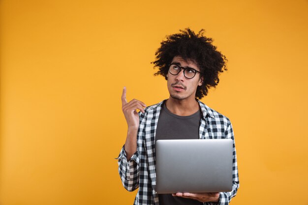 Portret van een peinzende jonge Afrikaanse man in brillen