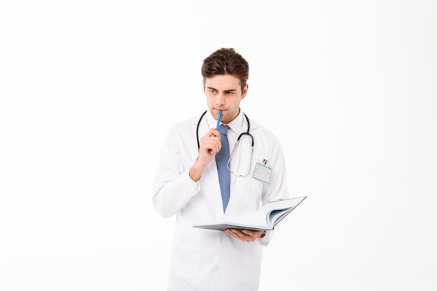 Portret van een peinzende jonge mannelijke arts met een stethoscoop