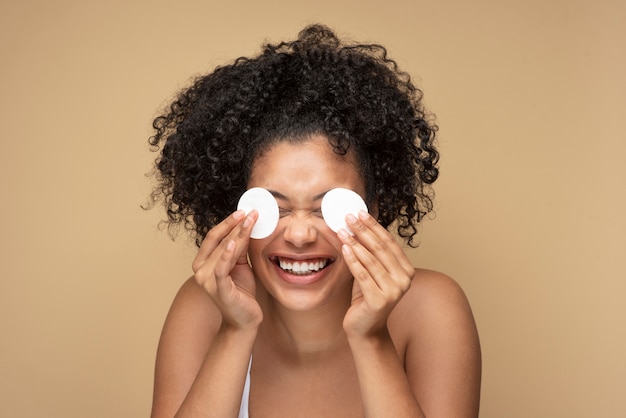 Gratis foto portret van een prachtige vrouw die haar make-up verwijdert met pads