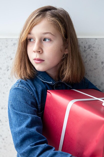 Portret van een schattig klein meisje met een rode geschenkdoos