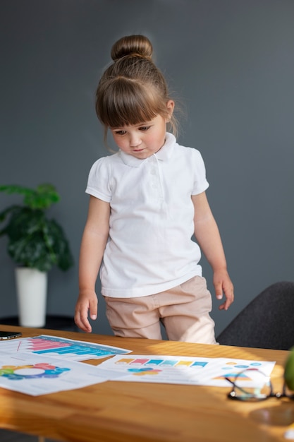 Gratis foto portret van een schattig meisje dat aan haar bureau werkt