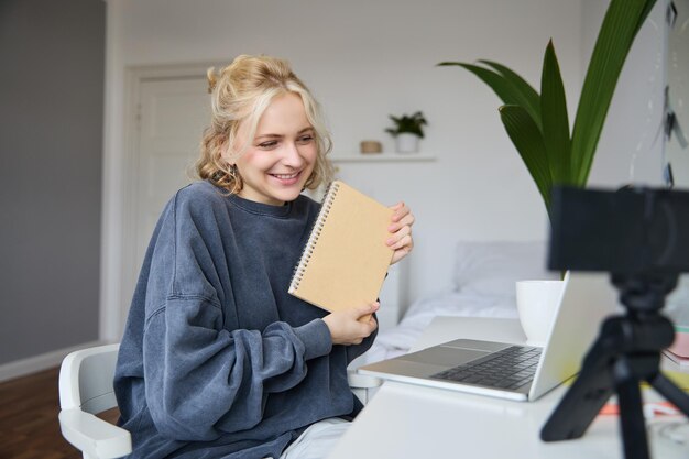 Portret van een schattige jonge vrouw een tienermeisje neemt video op met een digitale camera gebruikt een laptop om te maken