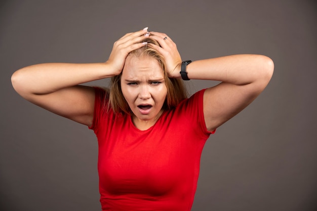 Portret van een schreeuwende jonge vrouw die zich over het donker bevindt.