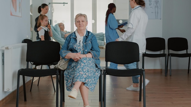 Portret van een senior patiënt die in de wachtkamer zit, een medische afspraak heeft voor een controlebezoek en overleg in de faciliteit. vrouw die wacht om met huisarts te praten.