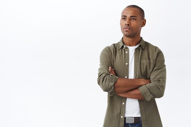 Portret van een serieus ogende, vastberaden jonge afro-amerikaanse man, kijkend met een gerichte doordachte uitdrukking aan de linkerkant van de kopieerruimte