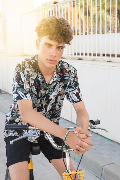 Portret van een serieuze jonge man zit op de fiets