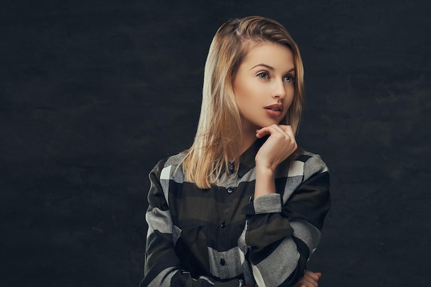 Gratis foto portret van een sexy blond meisje in een fleece shirt, poseren in een studio. geïsoleerd op een donkere achtergrond.