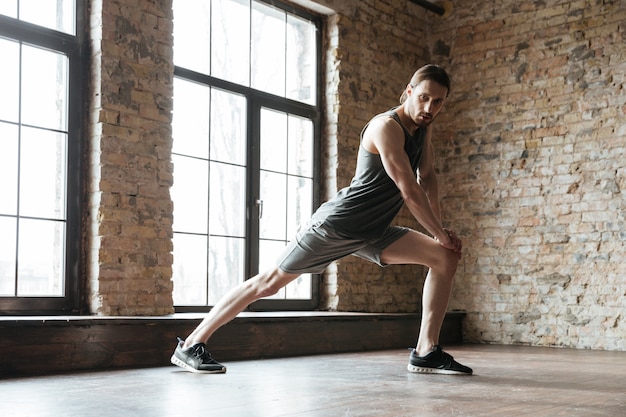 Portret van een sportman die bij de gymnastiek opwarmen