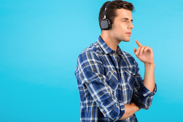 Portret van een stijlvolle, aantrekkelijke, knappe jongeman die naar muziek luistert op een draadloze koptelefoon met een leuke moderne stijl, een gelukkige emotionele stemming