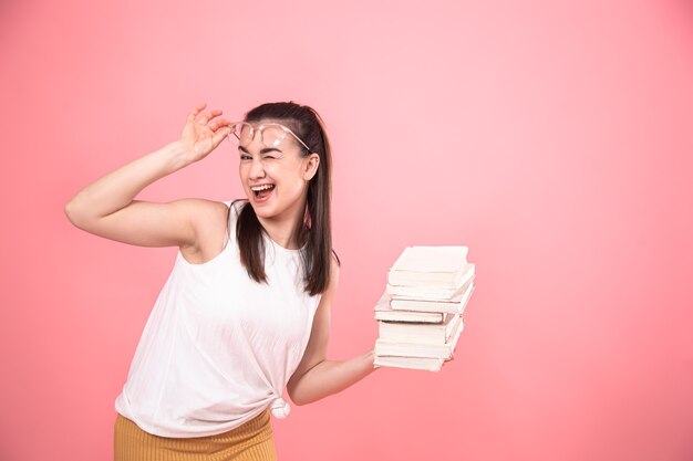 Portret van een studentenmeisje met glazen die met boeken in haar handen stellen. Concept van onderwijs en hobby's.