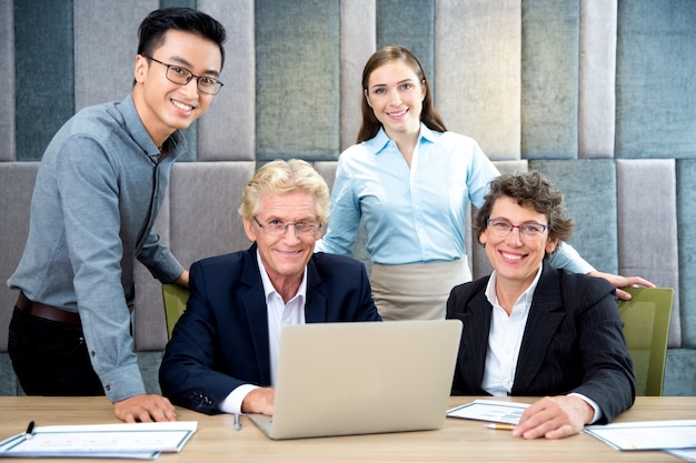 Portret van een succesvolle team op laptop in office