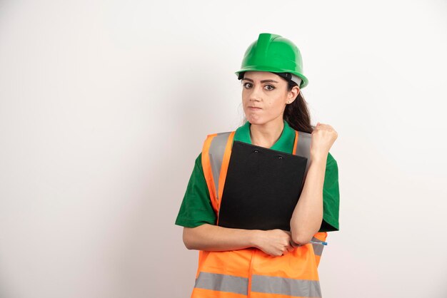 Portret van een succesvolle vrouwenconstructeur die helm en oranje veiligheidsvest draagt. Hoge kwaliteit foto