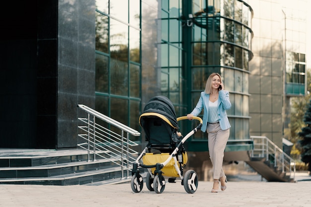 Gratis foto portret van een succesvolle zakenvrouw in blauw pak met baby