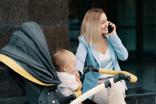 Portret van een succesvolle zakenvrouw in blauw pak met baby