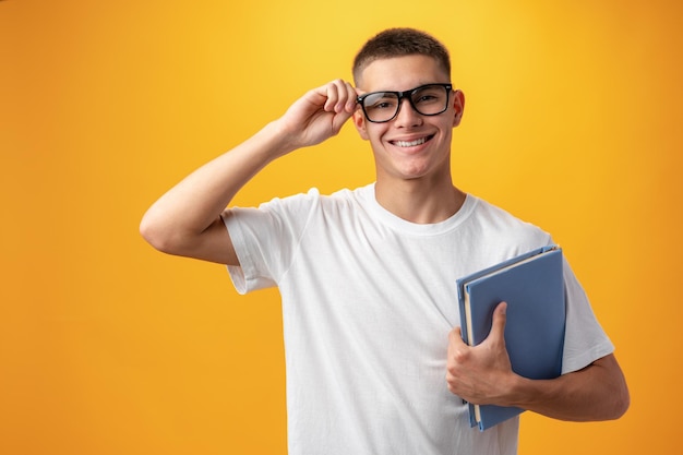 Portret van een tienerjongen die lacht tegen een gele achtergrond